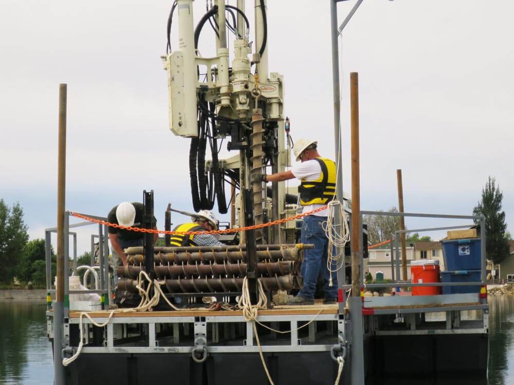 Drillers for Drilling Engineers use 3.25 in. hollow stem augers with their 7822DT machine on a barge on Erie Lake Reservoir.
