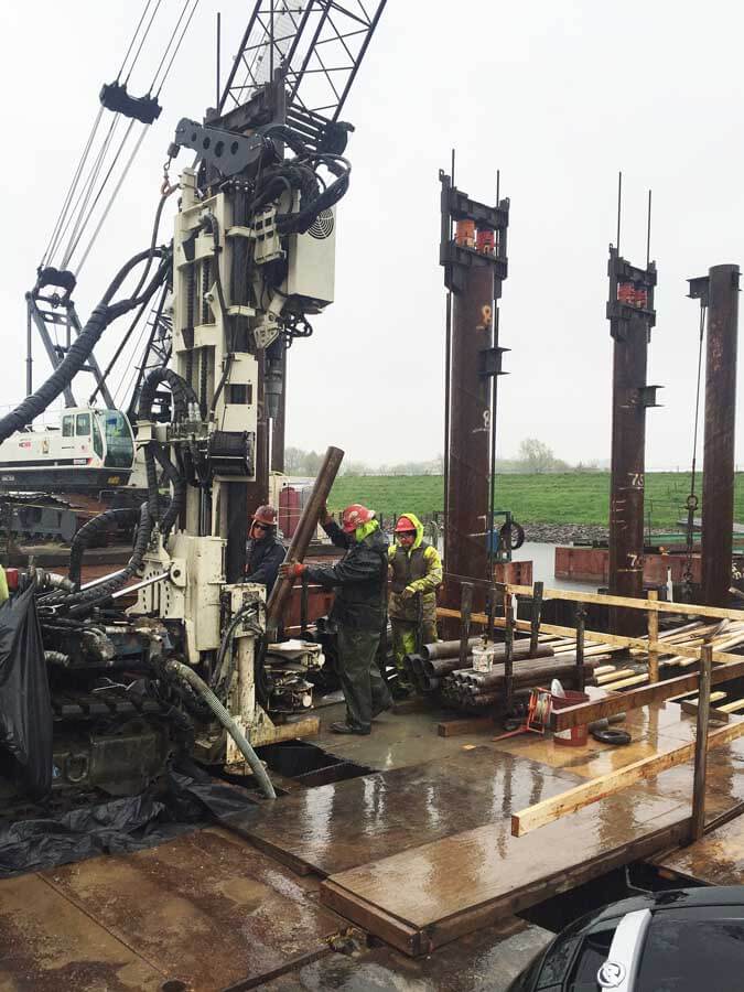 (l to r) Randy Crandell (at the controls), Shaun Biggs, and Chris Ruschmeyer add a stick of 6-in. casing to be advanced over a 4-in. core barrel using the 8140LC rotary sonic on a barge.