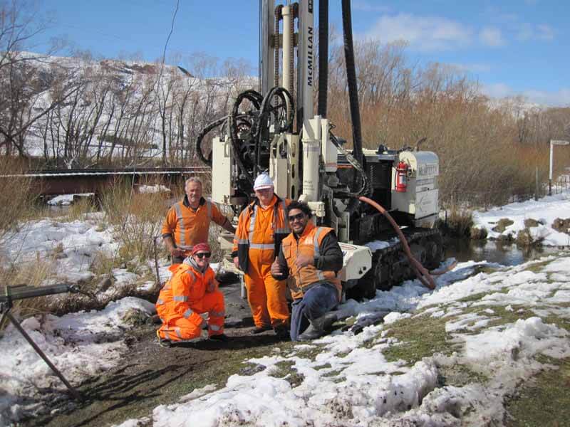 McMillan Drilling field team and two clients.  McMillian drillers are (far left) Chris Nee and (far right) Paul Taulava.