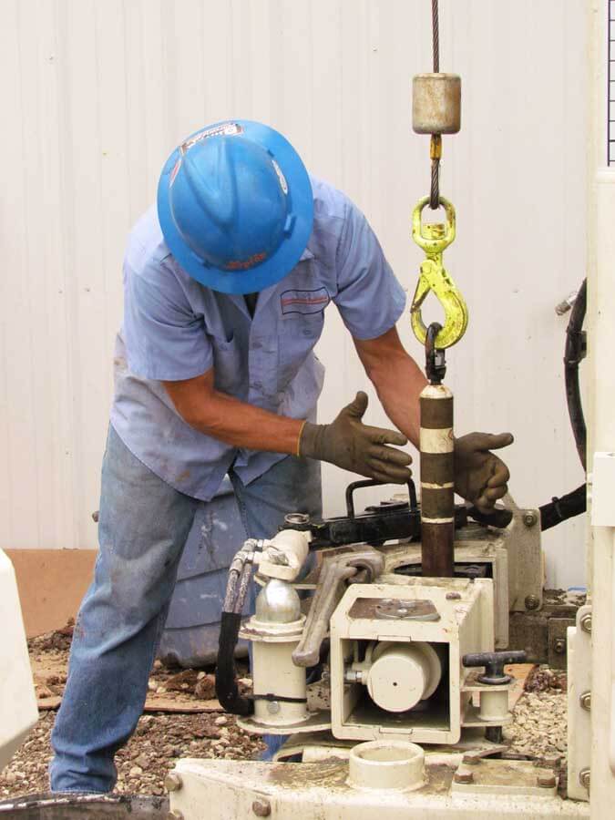 Today’s larger machines enable operators to handle long sections of inner rods with an overhead winch. The 2.25-in. Spring Assisted Swivel Pull Cap is designed to reduce operator fatigue when adding or removing these sections of rods to the inner tool string ... safely and easily. Above, Lee Shaw uses the Spring Assisted Swivel Pull Cap under a 3230DT during well installation. Tooling systems that benefit from this accessory include Sonic SDT45 and SDT60, and Direct Push DT45 and DT60. Geotechnical applicat