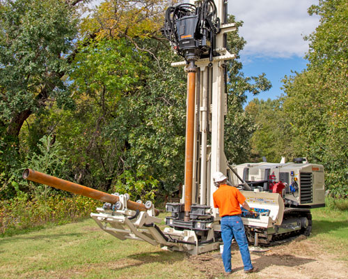 Rod handling system on 8250LS sonic drill rig increases safety for drillers while completing sonic boring.
