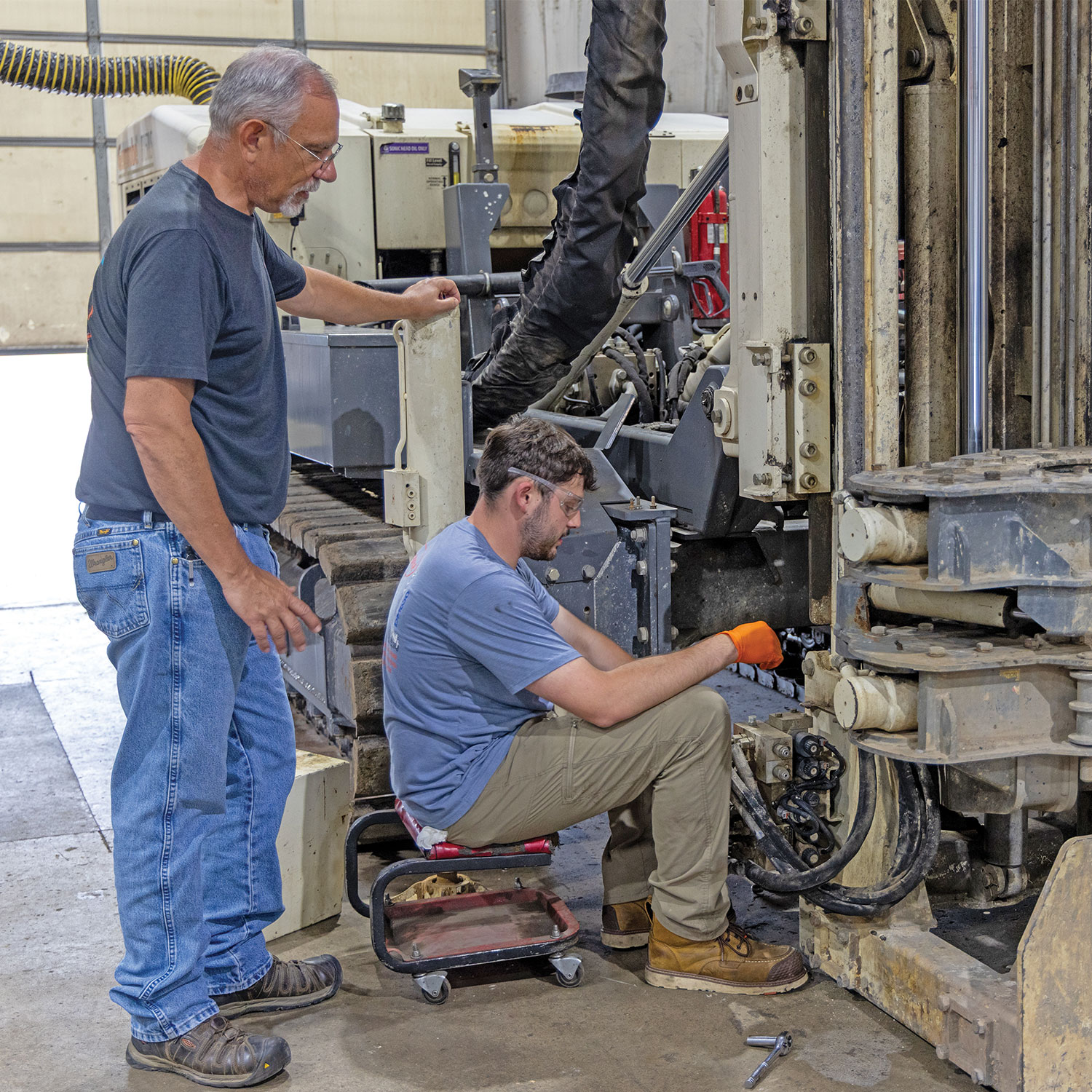 Troy Bourbon, sonic service rig specialist, guides Jackson Sprecker, service intern and mechanical engineering technology student, during removal of the original breakout.