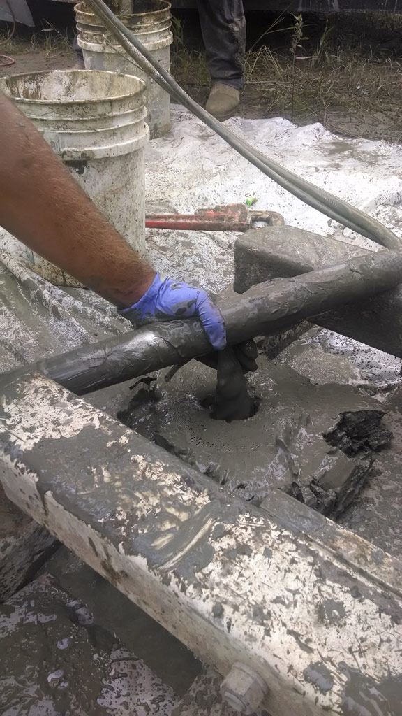 The tool can be positioned to top off the borehole with grout; whatever is not needed in the hole can be contained in a bucket.  This process is performed by pumping clean water through the grout pump and line. Approximately 10 gallons of water will flush a 250-ft grout line clean of neat cement.