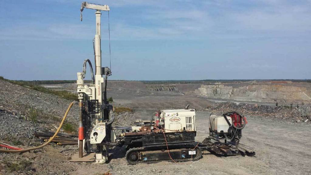 Geotechnical information and confirmatory samples for a new gold mining site were gathered in Canada using a Geoprobe® Direct Push machine. The mining company was constructing an open pit mine and building a berm surrounding the entire mine. Geotechnical information was collected using standard penetration tests in the overburden by casing the hole with hollow stem augers and using split spoon samplers until they hit bedrock. They continued into the rock, through some pieces as large as a full-sized truck, 